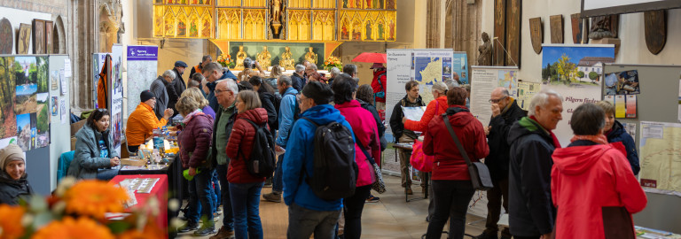 Messestände  Pilgern im Chorraum von St. Jakob